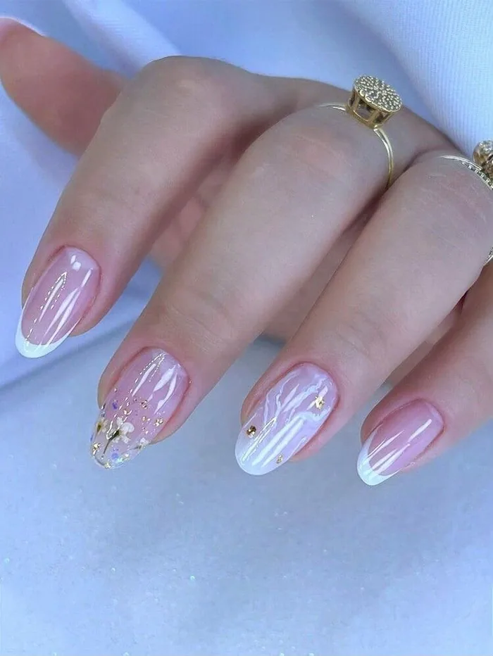 Unhas nude com nail art delicada em flor e detalhes dourados